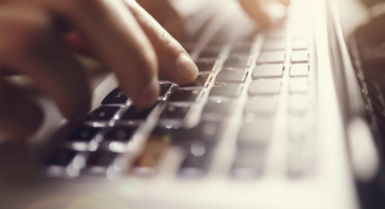 Fingers typing at keyboard